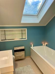 a bathroom with a large bath tub and a skylight at Villa med panoramautsikt, stor uteplass og 100 m fra badestrand in Bergen