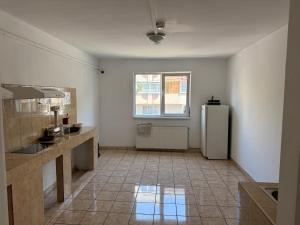 a kitchen with a refrigerator and a tile floor at ZipStay Inn in Cluj-Napoca
