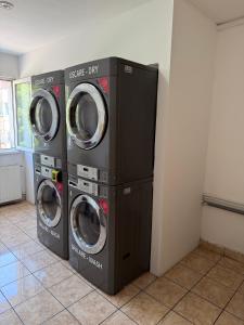 three washing machines in a room next to a wall at ZipStay Inn in Cluj-Napoca