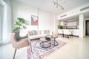 a living room with a couch and a table at Stella Stays Barsha Heights in Dubai