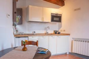 a kitchen with white cabinets and a wooden table at Cozy Bruni House in Florence in Florence