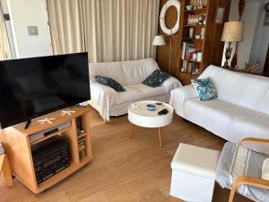 ein Wohnzimmer mit einem großen Flachbildfernseher in der Unterkunft Fantásticas vistas al mar en el Faro in Faro de Cullera + 30 Fotos