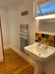 a bathroom with a white sink and a window at Trevigue Cottage in Bude +48 photos