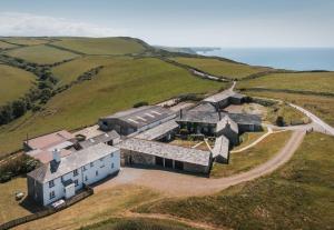 an aerial view of a building on a hill with the ocean at Trevigue Cottage in Bude