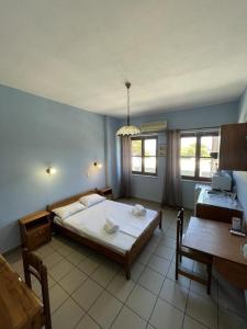 ein Schlafzimmer mit einem großen Bett und einem Schreibtisch in der Unterkunft Syros Studios in Ermoupoli
