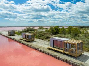 a group of modular houses on the side of a river at Nuits Salines Aigues-Mortes in Aigues-Mortes