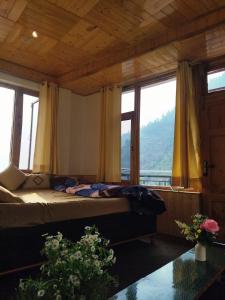 a bedroom with a bed with a view of a mountain at The Pine Pause-Hallan-i in Manāli