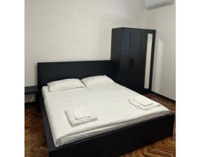 a bed with a black headboard and white sheets at Fiore Villa in Fiorenzuola dʼArda