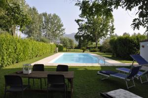 Una mesa y sillas junto a una piscina. en La Capannina, en Capannori