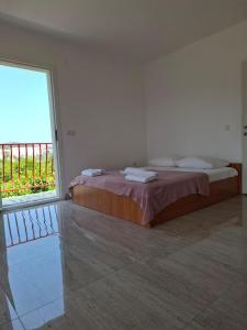 a bedroom with a bed and a large window at Apartmani Urlic in Sreser