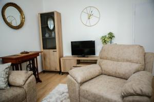 a living room with a couch and a chair and a television at Adi apartment in town centar in Konjic
