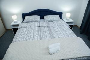 a bedroom with a large bed with two night stands at Adi apartment in town centar in Konjic