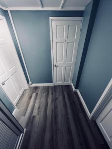 an empty room with a white door and blue walls at Modern Oxford Retreat - Free parking in Oxford +1 photo