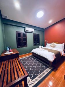 a bedroom with a bed and a bench in it at 公园龍门客栈 in Luang Prabang
