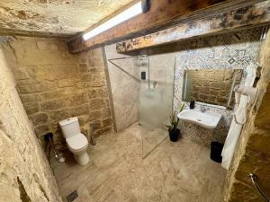 a stone bathroom with a toilet and a sink at Kappella boutique in Malta in Żurrieq +5 photos