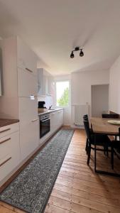 a kitchen with white cabinets and a table and a dining room at Villa Mediterrane - Apartment Venice in Frankenthal