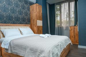 a bedroom with a bed with white sheets and a window at Golden Pheasant in Tbilisi City