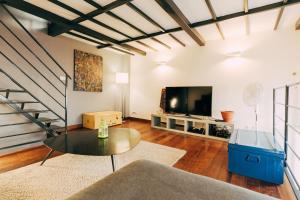 un soggiorno con un tavolo e una TV di Maison Cœur Historique du Vieux Lille de 98m2 a Lille