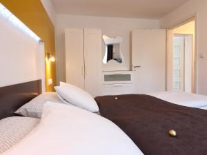 a bedroom with two beds and a kitchen at TS Apartments in Traunstein