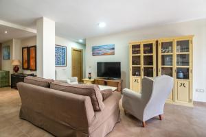 a living room with a couch and a tv at Apto Llanes Piscina y Playa – El Recreo de Celorio in Celorio