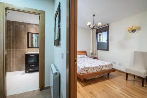 a bedroom with a bed and a tv in a room at Apto Llanes Piscina y Playa – El Recreo de Celorio in Celorio +35 photos