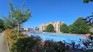 a tennis court in front of a building at Apto Llanes Piscina y Playa – El Recreo de Celorio in Celorio