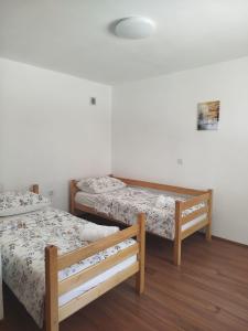 a room with three beds and a white wall at Apartman ANNA in Jajce