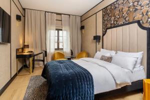 a hotel room with a large bed and a desk at Hotel Experior Boutique - Destigo Hotels in Kraków