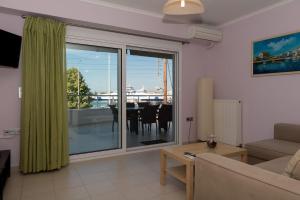 a living room with a couch and a large glass window at Eirini luxury Apartments in Keramoti