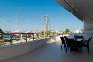 a balcony with a table and chairs and a view of a city at Eirini luxury Apartments in Keramoti
