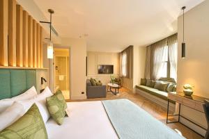 Un dormitorio con una cama y una sala de estar. en The Wings Hotels Pera, en Estambul 116 fotos más