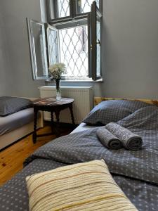 two beds in a bedroom with a table and a window at Museum Apartment in the City Center in Ráckeve