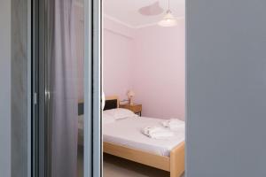 a small bedroom with a bed and a mirror at Eirini luxury Apartments in Keramoti