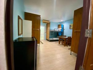 a living room with a refrigerator and a dining room at Riverside Pak Nakon Restaurant & hostel in Ban Ko Mai Phai