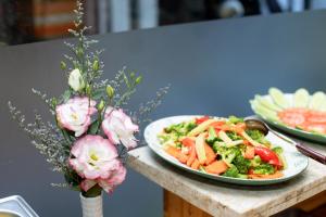 a table with two plates of food and flowers at Anh Hotel in Ho Chi Minh City +27 photos