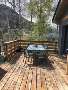 a table and chairs on a wooden deck at La villa des 3 frontières in Porté-Puymorens