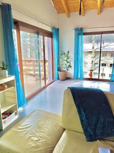 a living room with blue curtains and a couch at La villa des 3 frontières in Porté-Puymorens