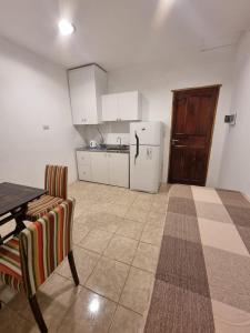 a kitchen with a table and a white refrigerator at Alojamiento Almendra in Paso de los Libres