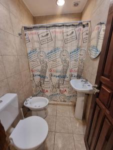 a bathroom with two toilets and a shower curtain at Alojamiento Almendra in Paso de los Libres