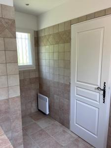 a bathroom with a door and a tiled shower at Villa à Salazac - Piscine - Gorge de l'Ardèche in Salazac +36 photos