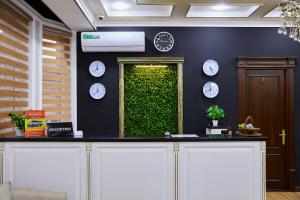 Art Elite في طشقند: غرفة ذات جدار أخضر مع ساعات عليها +18 صورة