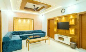 a living room with a blue couch and a tv at Bhanus Beach Enclave in Kannur