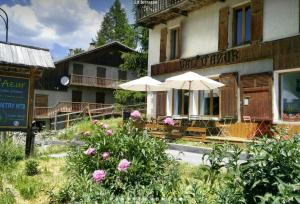 a building with tables and umbrellas in front of it at CASA-Salon Bella Ciao Suite pour 5 personnes in Molines-en-Queyras