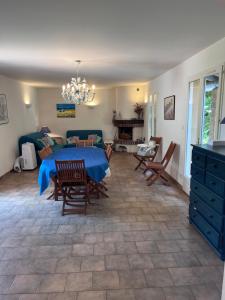 a living room with a blue table and chairs at Villa à Salazac - Piscine - Gorge de l'Ardèche in Salazac