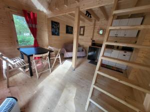 a log cabin with a table and a couch at Zagroda Zabłocie Domek Między Drzewami in Zabłocie