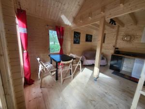 a room with a table and chairs in a cabin at Zagroda Zabłocie Domek Między Drzewami in Zabłocie