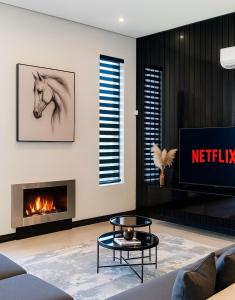 ケープタウンにあるPhoenix Homeの暖炉とテレビのあるリビングルーム