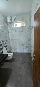 a bathroom with a toilet and a window and a door at Bhanus Beach Enclave in Kannur +17 photos