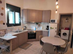 a kitchen with wooden cabinets and a table and a table and chairs at Kavala Summer in Kavála