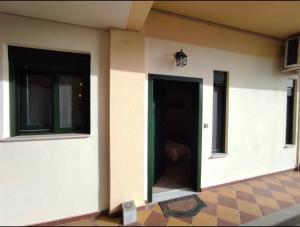 a building with a black door and two windows at Kavala Summer in Kavála